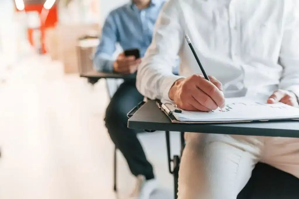 Sitting by the tables and learning new stuff. Group of professional business people is in the office